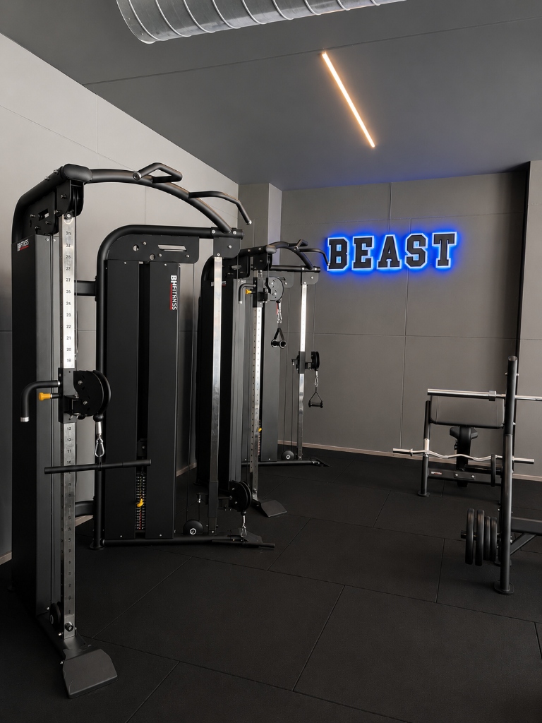 Cable crossover machines with neon BEAST sign