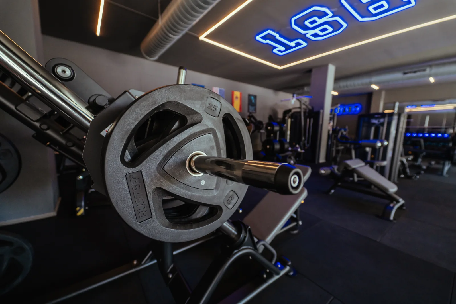 Close view of a loaded strength machine beneath the blue BST ceiling sign